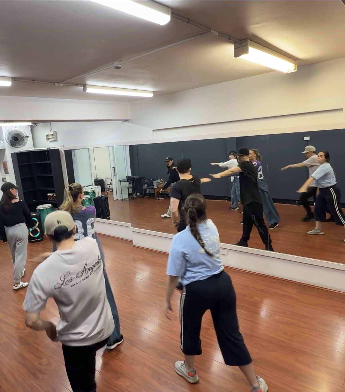Dancers working through choreography together in front of the studio mirror